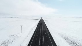 A straight highway extends through a vast snow-covered plain.Utility poles run alongside the road,disappearing into the horizon.The flat landscape and create an open view of the winter terrain.

 - Powered by Shutterstock - Get 15% off with code: PIKWIZARD15