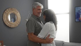 Middle-aged couple dancing happily in a cozy living room, the woman and man share a tender moment together in a warm home environment filled with love and intimacy. - Powered by Shutterstock - Get 15% off with code: PIKWIZARD15