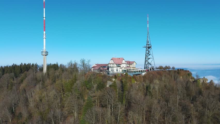 uetliberg mountain peak hotel restaurant communication tower overlooking zurich switzerland forest covered landscapes via upward aerial drone shot forested