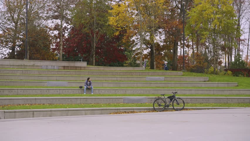a man with a bicycle resting near lake lafarge.