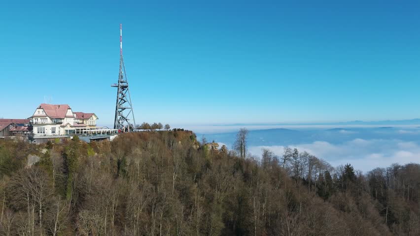 historical building housing hotel restaurant situated uetliberg mountain peak overlooking zurich switzerland forest covered surroundings using aerial panning shot drone