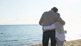 Senior mature couple hugging enjoying outdoor recreation walking on beach. Old husband wife embracing with tenderness love enjoying sweet bonding. Grandmother grandfather together. Family moment love - Powered by Shutterstock - Get 15% off with code: PIKWIZARD15