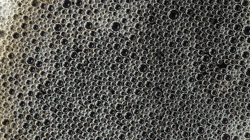 Popping bubbles on top of a soft drink. Macro shot.