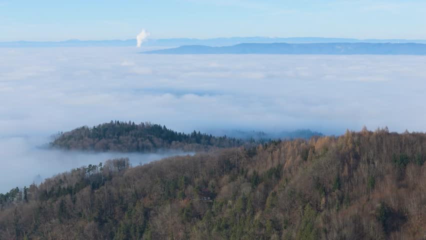 foggy mountain peaks tree covered forests during day scenery switzerland clouds enhancing aerial drone view hazy backdrop scenic perspective swiss alps