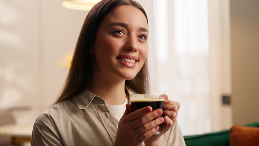 Camp peaceful cozy relaxed Caucasian woman female girl lady homeowner at own apartment indoors relaxing in living room home holding cup of tea sniffing aromatic coffee drinking aroma drink atmosphere