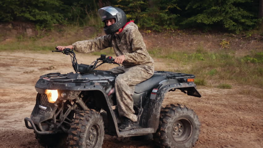 rugged terrain, rough trail, camouflage adventure. Group of ATV enthusiasts, dressed in camouflage, powers through dusty, uneven trail, feeling adrenaline of off-road riding.