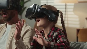 Excited Caucasian family father with emotional scared amazed daughter dad man male with kid girl child at home at couch enjoying online gaming play in VR helmet glasses virtual reality modern tech - Powered by Shutterstock - Get 15% off with code: PIKWIZARD15