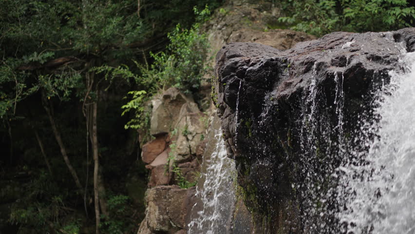 Close up waterfall lush strong water falling into a subtropical rock stone water landscape at Misiones Highs, Salto El Yerba, El Soberbio, Argentina