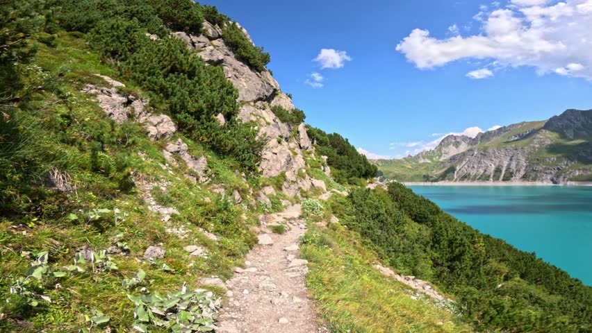 POV of Lunersee hiking trail in the Austrian alps, turquoise lake and majestic mountains