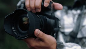 Professional photographer adjusting camera settings, preparing lens near scenic landscape backdrop - Powered by Shutterstock - Get 15% off with code: PIKWIZARD15