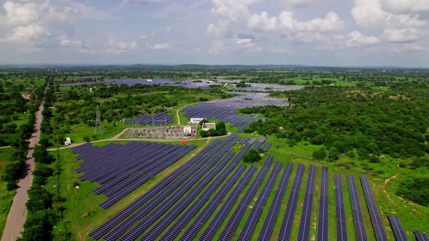 solar power plant with sub station and trees at tekmal village, medak dist, telangana, india. day time, tilt down, drone shot, 4k.