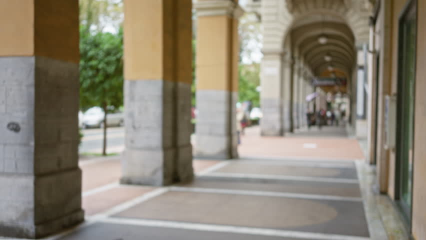 Defocused street scene in la spezia with arched walkway showcasing european architecture and blurred background, capturing essence of urban life in italy.