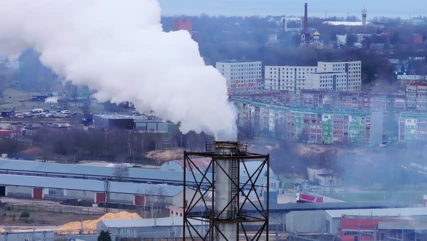 Smoke rising from an industrial chimney over city, environmental issues, spring