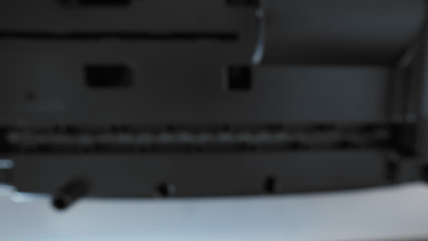 A close up view of a paper shredder cutting a sheet of office paper, document into thin strips.