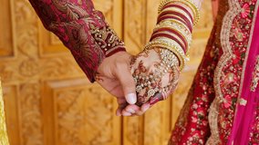 Couple standing together, holding hands, dressed in traditional red Indian clothes, Elements of Hindu wedding. Close up - Powered by Shutterstock - Get 15% off with code: PIKWIZARD15
