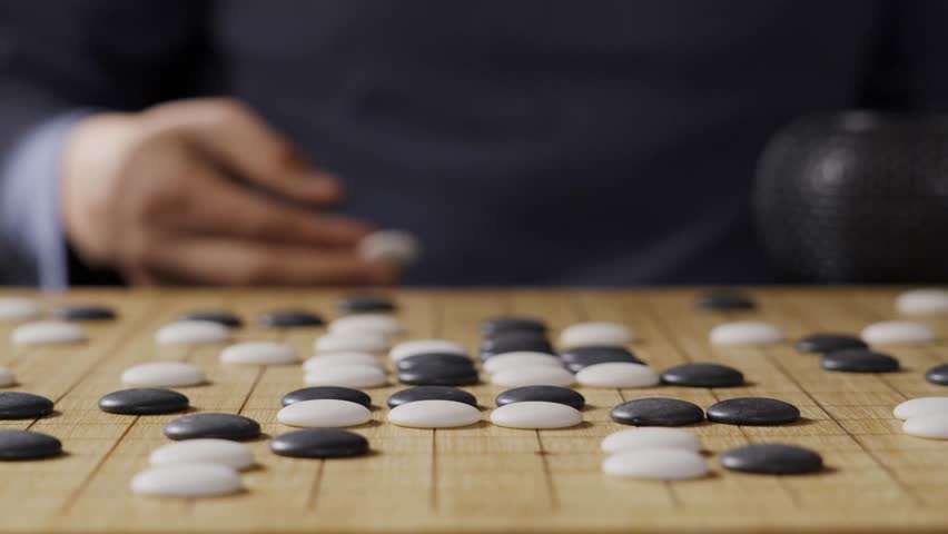 close up of player hand make a move in Go game(Weiqi),Traditional trategy board game