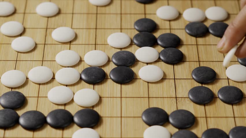 close up of player hand make a move in Go game(Weiqi),Traditional trategy board game