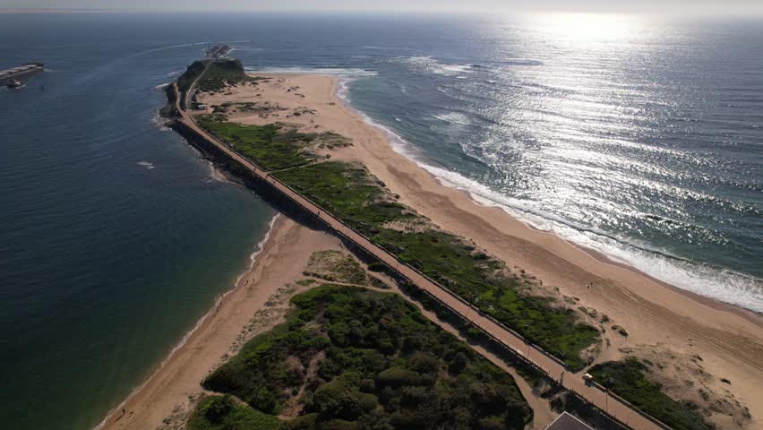 Horseshoe Beach And Nobbys Beach At Entrance Of Hunter River In Newcastle, NSW, Australia. aerial pullback shot