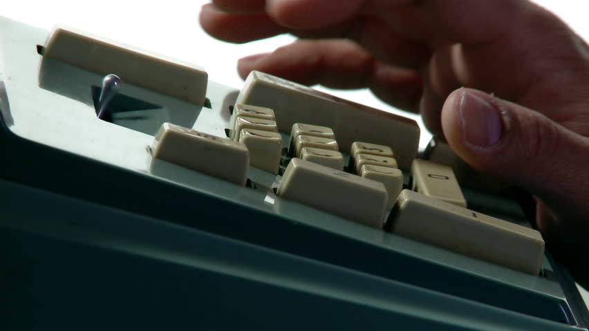 Tight close up on fingers operating an old-fashioned adding machine.