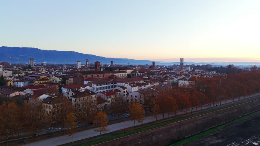 Aerial panoramic view of Lucca city rooftops at sunrise or sunset in Tuscany, Italy
