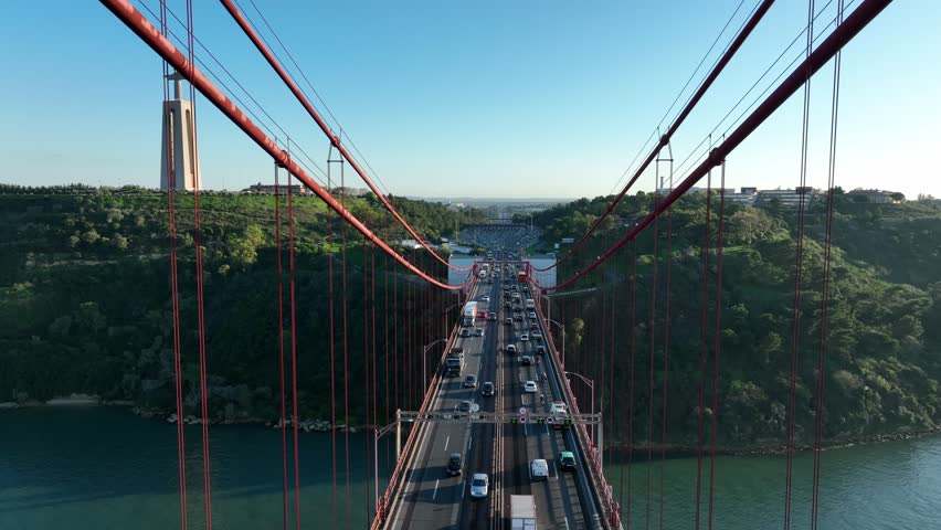 The 25 April bridge (Ponte 25 de Abril) located in Lisbon, Portugal, crossing the Targus river. Drone. 4k
