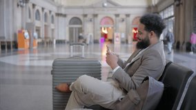 Busy train station, african american businessman unwinds with his smartphone, exemplifying modern travel, effective communication, and his dynamic lifestyle in todays everevolving urban environment - Powered by Shutterstock - Get 15% off with code: PIKWIZARD15