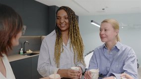A cheerful group of diverse businesswomen are happily conversing in a modern office setting, showcasing their collaboration and creating a positive and inspiring work environment together - Powered by Shutterstock - Get 15% off with code: PIKWIZARD15