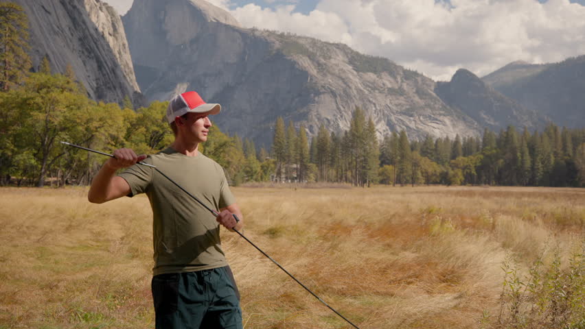 Breathtaking Yosemite National Park, hiker man folding tent pole surrounded by iconic landscapes like El Capitan and Half Dome, perfect for hiking and camping enthusiasts to explore and enjoy