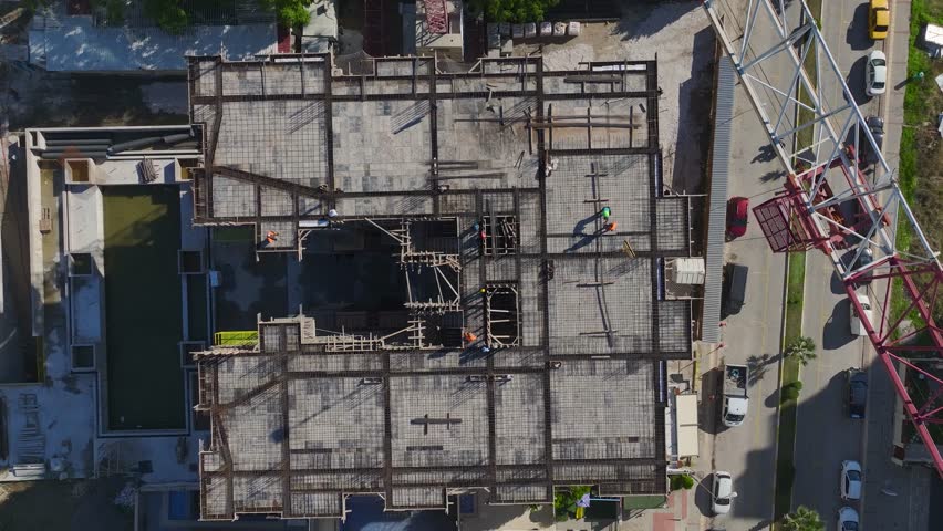 Aerial Video: Aerial View of Construction Workers Preparing Floors and Installing Walls on a Dynamic Site