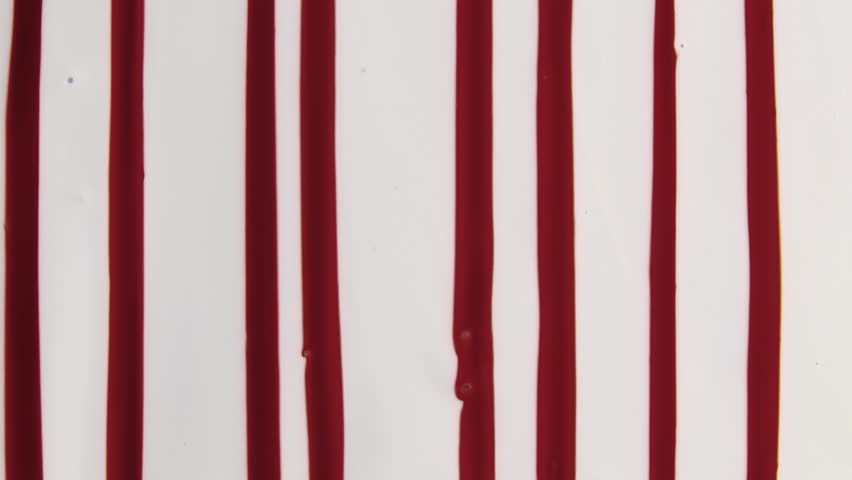 Multiple lines of blood running down a white fluid surface.
