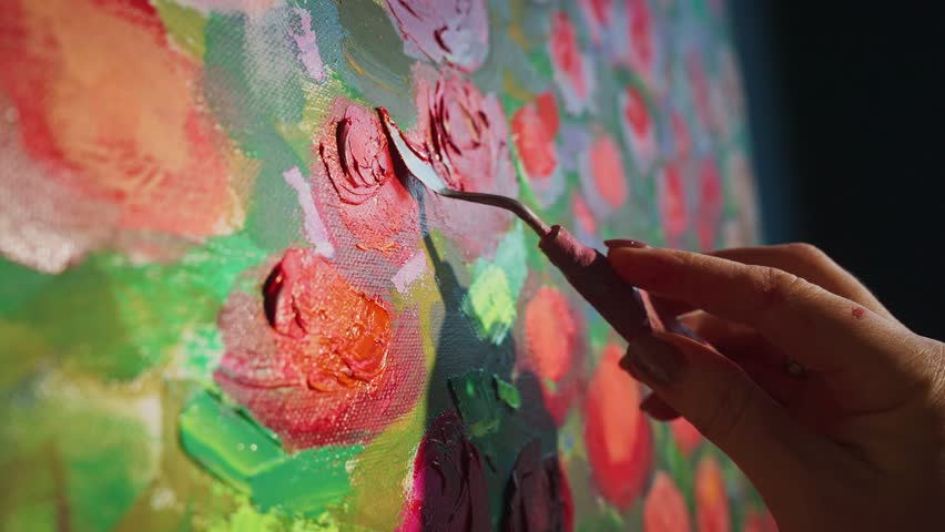 Experienced artist creating vibrant floral painting, using palette knife for layering rich textures and dynamic colors on canvas with professional artistic precision