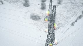 Power lines stretching across a snow-covered landscape with digital battery icons overlayed, symbolizing energy storage and the rising cost of electricity. Concept of power supply and market trends - Powered by Shutterstock - Get 15% off with code: PIKWIZARD15