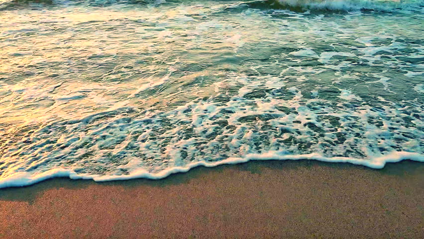 Rolling sea waves with white foam on the sandy beach of the seashore on a sunny morning. Nature. Natural background