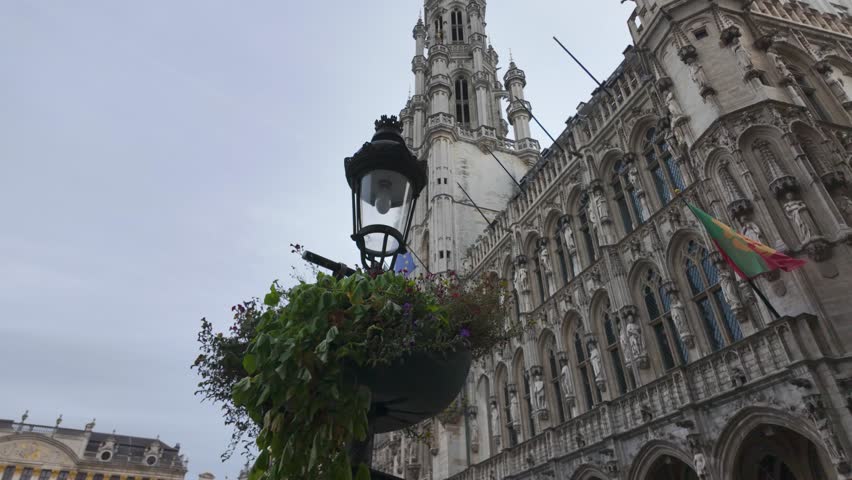 A tall Gothic tower and greenery decorate Brussels Town Hall in Belgium, Europe