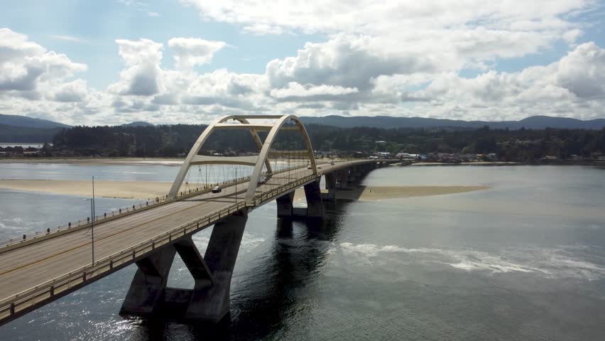 Alsea Bay Bridge spanning the Alsea River in Waldport, Oregon, along HWY 101. Cars Driving Across Bridge Crossing on Summer Day Road Trip. South of Newport, North of Florence and Yachats