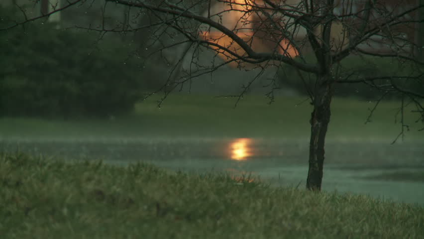 Cars passing, blurred, through the rain, during a big storm. Slow motion with