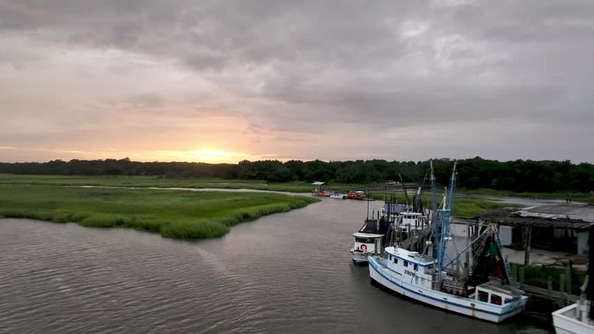 aerial fast pullout from shrimp boats at dock near beaufort sc, south carolina
