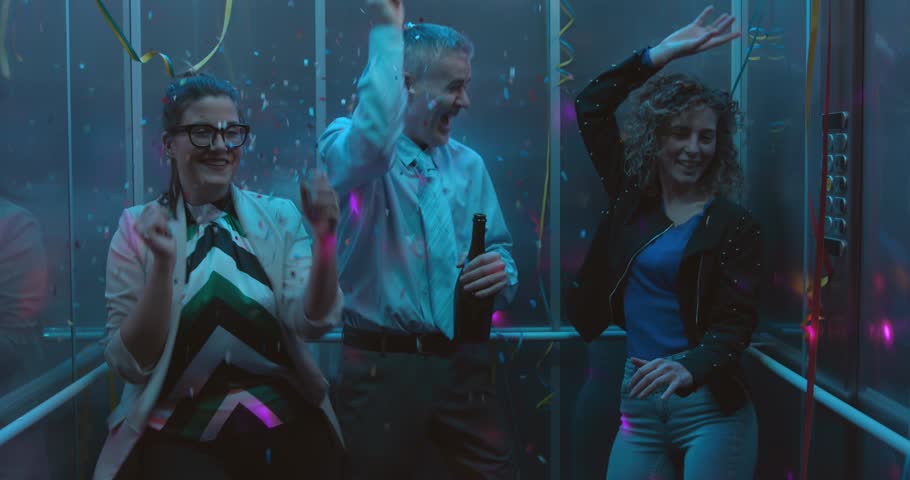 Crazy business people celebrating and having fun at the office party, they are drinking wine and dancing together in the elevator