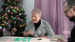 Old woman pensioner plays Bingo. A grandmother with her family plays board games under the Christmas tree at home holiday. Lotto - Powered by Shutterstock - Get 15% off with code: PIKWIZARD15