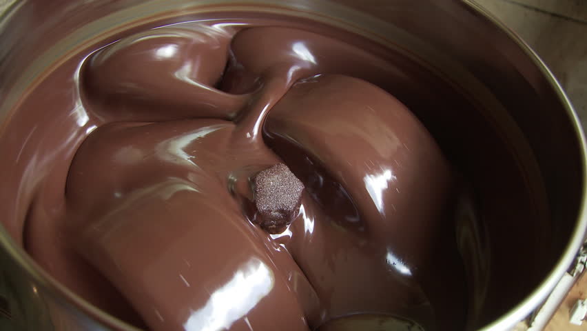 Chocolate turning over and over, blending and smoothing in a process known as