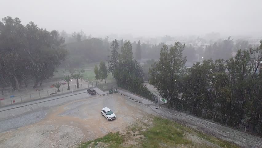 Heavy rain hits urban park with intense downpour in quiet neighborhood amid stormy weather conditions
