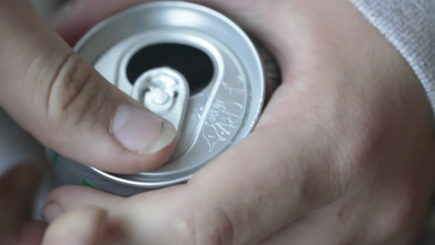 Teenage hands open a can of soda. Shot with a macro lens and shallow depth of
