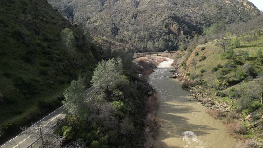 This high-altitude perspective reveals Cache Creek’s path, flanked by rolling hills and lush vegetation.