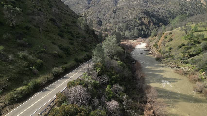An expansive aerial perspective reveals the diverse terrain surrounding Cache Creek’s path through Rumsey. A lone car drives through the path of Cache Creek.