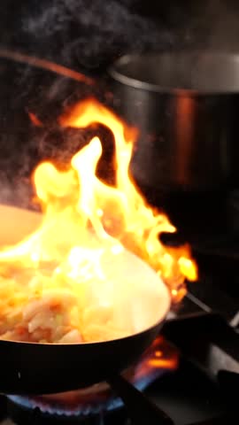 Tripe in a pan swirls, sizzling as a big flame licks the edges, creating an intense heat. The crispy edges char slightly while the center stays tender.