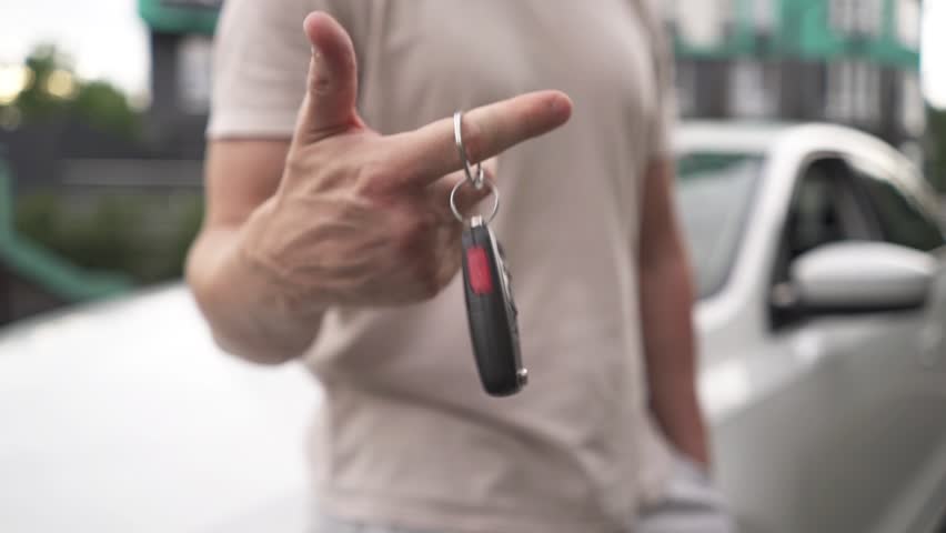Male hand gives a car keys to male hand in the car dealership close up.