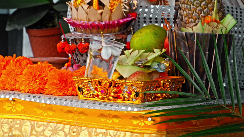 An old stone statue of Ganesha covered with moss, standing on the street 