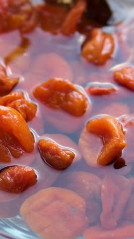 Dried apricots wash rise up and fall down. On a blue background. Filmed is slow motion 1000 fps.