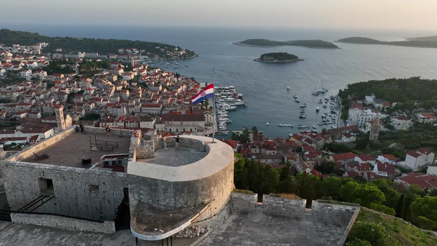 Parallax drone shot of Hvar City Fortress in the day with sunshine and Adriatic Sea in Croatia
