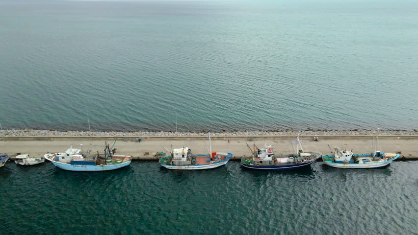 Fishing boats moored at the protected port of Nea Michaniona coastal town in Greece.